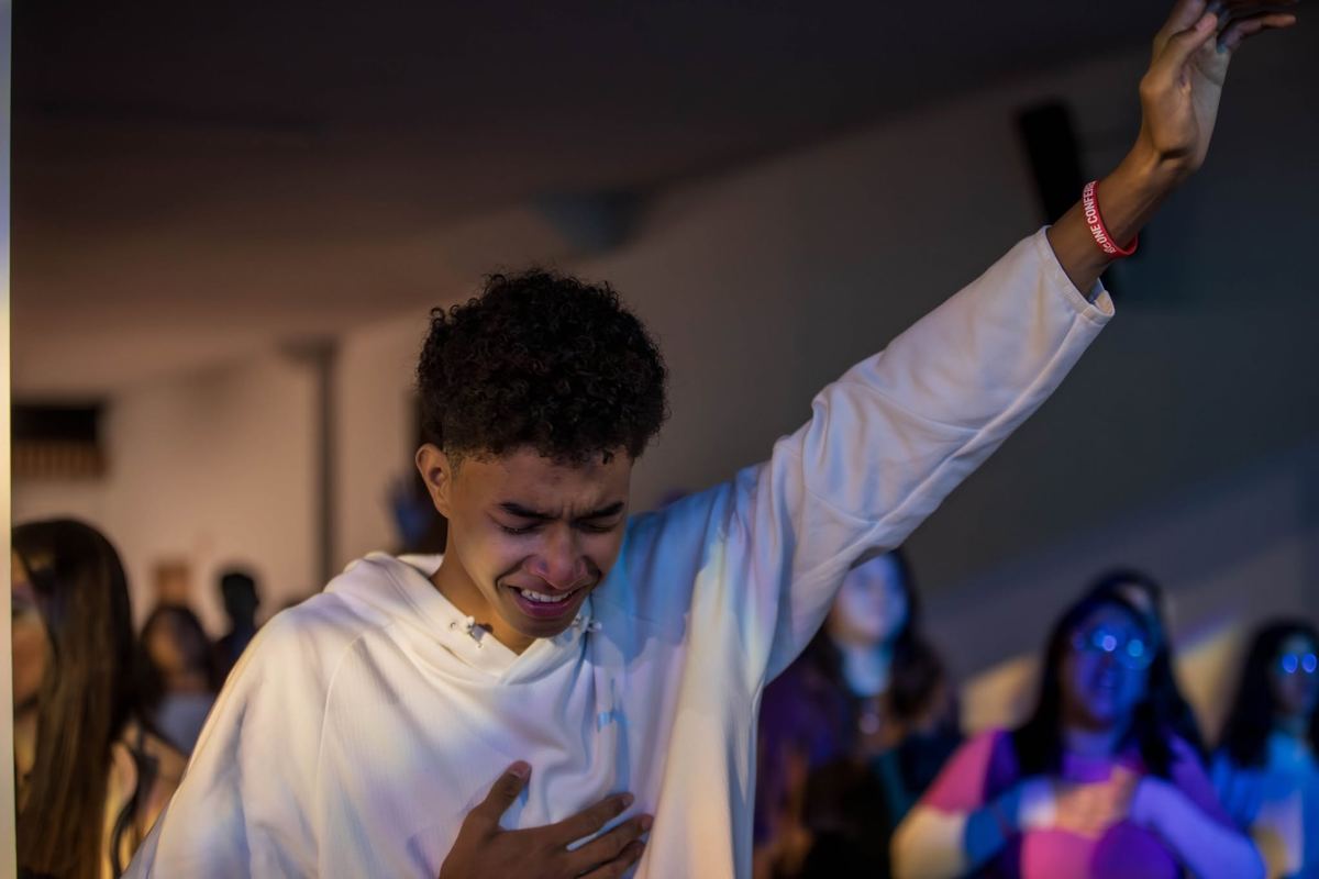 Young man worshipping with hand raised